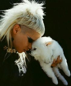 a woman with blonde hair holding a white cat