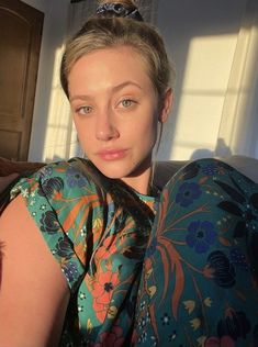 a woman sitting on top of a couch next to a window