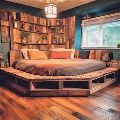 a bed made out of wooden pallets in a room with wood flooring and blue walls