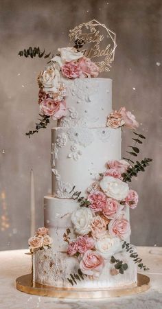 a white wedding cake with pink flowers and greenery