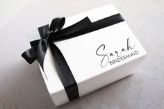 a white box with a black ribbon and the word sarak bridesmaid on it