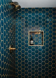 a bathroom with blue and gold tiles on the walls