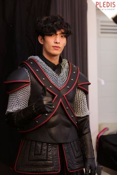 a young man dressed in armor and gloves