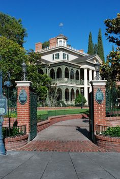 a large house with an iron fence and gated entry way leading into the front yard