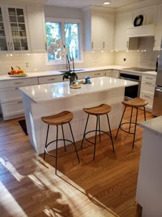 a kitchen with two stools and an island in front of the stove top oven