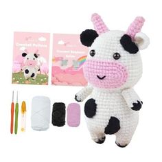 a crocheted cow is next to the kit for making it's own toy