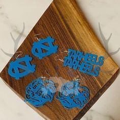 the earrings are made out of wood and have blue letters on them