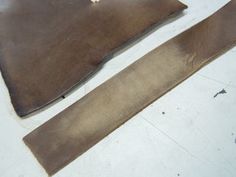 two pieces of leather sitting on top of a table