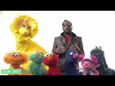 a man standing in front of sesame characters