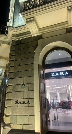 the entrance to zara is lit up at night