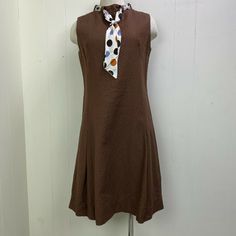 Vintage c. 60s Mod style textured brown shift dress with polka dot scarf collar. Sleeveless. Zipper down the back. Mock neck. No tags. Approximately a size 6. Wear to the seams, light staining on scarf. Measurements (flat): Shoulder to shoulder: 14.5" Armpit to armpit: 18" Waist: 18" Hips: 32" Bottom hem: 28" Length: 37" SKU FV-CB18-055 Fitted Brown A-line Sleeveless Dress, Brown A-line Sleeveless Dress, Fitted A-line Sleeveless Dress In Brown, Fitted A-line Sleeveless Brown Dress, Polka Dot Scarf, Mod Style, 60s Mod, Mod Fashion, Light Stain