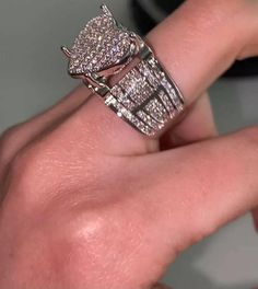 a woman's hand with a diamond ring on top of her finger and an engagement band in the middle