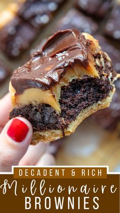 a hand holding a half eaten chocolate brownie