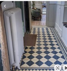 a hallway with an old radiator and black and white checkered flooring