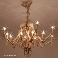 a chandelier with skulls and lights hanging from it's sides in a room