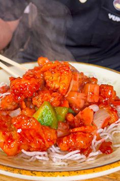 a plate full of food with chopsticks sticking out of it