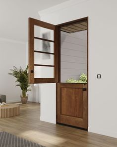 an open wooden door in a white room with potted plants on the wall and wood flooring