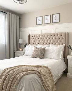 a bedroom with a large bed and two pictures on the wall above it's headboard