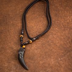 This dramatic looking pendant is made from natural stone and obsidian (volcanic glass) in the shape of a wolf's tooth. Wolf heads adorn either side. It's a statement piece that's great for everyday wear, or as a gift for someone who shares your love of wolves and will make an excellent addition to any wardrobe.. Available with rope or bead style chains. Pendant size approx - 63 x 14mm (2.5 x 0.5 inches). Chain length approx 60cm (23") Norse Jewelry Men, Mens Stone Necklace, Men Stone Necklace, Man Necklaces, Viking Necklace Men, Wolf Tooth Necklace, Viking Wolf, Wolf Tooth, Wolf Teeth