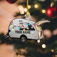 a camper ornament hanging from a christmas tree