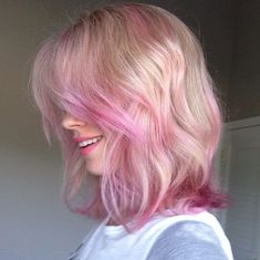 a woman with pink hair is smiling for the camera