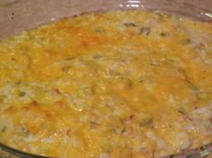 a casserole dish with cheese and other toppings in a clear glass bowl