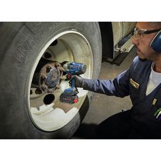 a man working on a tire with a drill