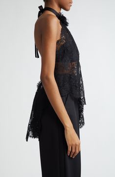 The Italian house's obsession with lace brings dark romance to your collection with a sheer Chantilly top cut with a diagonally slanted, asymmetric hem. A back-baring halter neck centered with a voluminous rosette appliqué brings drama to your look, while a cascading bow at the nape adds a coquettish touch. Adjustable back tie closure Halter neck Sheer; base layer shown not included 68% cotton, 22% nylon, 10% silk Dry clean Made in Italy Designer Clothing Chic Delicate Lace Top For Party, Chic Evening Tops With Lace Bodice, Delicate Lace Top For Party, Elegant Black Top With Lace Closure, Sheer Sleeveless Lace Top For Evening, Chic Scalloped Lace Tops For Evening, Chic Evening Tops With Scalloped Lace, Elegant Sheer Lace Top For Night Out, Elegant Delicate Lace Top For Night Out