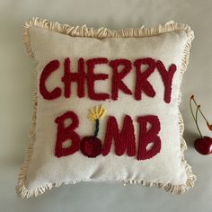 a pillow with the words cherry bomb written on it next to a cherries berry