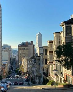 a city street lined with tall buildings and parked cars