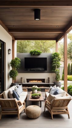 an outdoor living area with couches, chairs and a fire place in the center