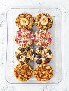 granola bites with fruit and nuts in a plastic container on a white table top