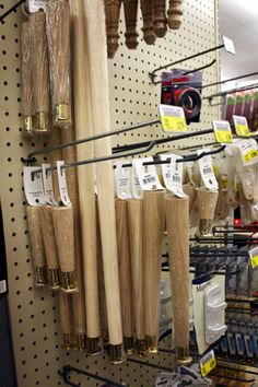 some baseball bats are hanging on the wall in a store with other items for sale