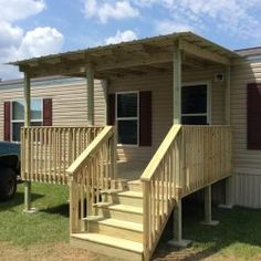 a mobile home with stairs leading up to the front door and second story porch area