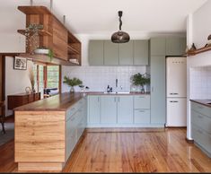 a kitchen with wood flooring and blue cabinets in the center, surrounded by wooden floors