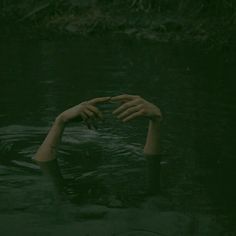 a person in the water holding their hands up