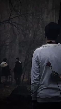 a person standing in front of a tree with a rose on it's back