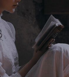 a woman in white dress reading a book