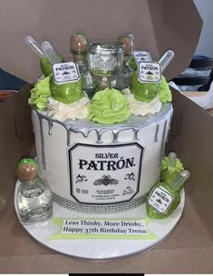 a birthday cake made to look like a silver patron bottle with green decorations on top