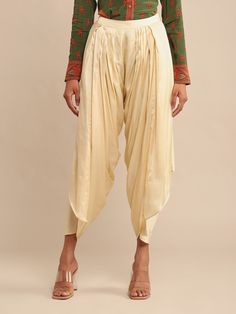 Editor's Note Drape yourself in elegance with our ecru satin draped dhoti salwar. This unique and stylish piece adds a touch of sophistication to your wardrobe, making it an excellent choice for special occasions or when you want to make a fashionable statement. Note: Top is for styling purposes only Fabric: Satin Color: Ecru Components: Salwar Closure: Elastic Note: Product colour may slightly vary due to photographic lighting sources Care: Dry clean only About the DesignerRitu Kumar is one of Dhoti Salwar, Designer Bottoms, Salwar Pants, Drape Pants, Ritu Kumar, Wrap Pants, Trendy Blouses, Satin Color, Bottom Clothes