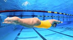 a woman in a yellow swimsuit swimming under water