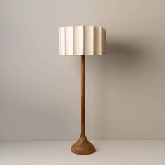 a wooden lamp with a white shade on it