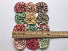 a ruler is shown next to several different fabric flowers