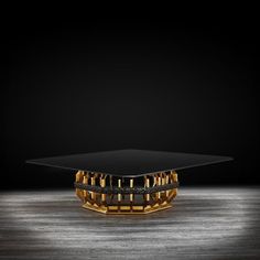 a glass table sitting on top of a wooden floor in front of a black wall