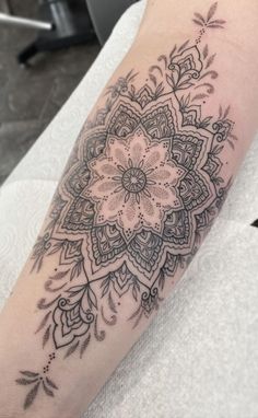 a woman's arm with a flower tattoo on the left side of her arm