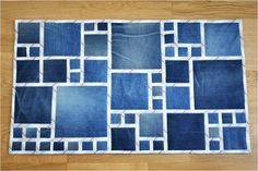 a rug made out of blue jeans on a wooden floor with white trimmings