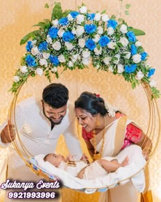 a man and woman standing next to a baby in a crib with flowers on it