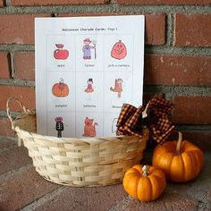 two small pumpkins sitting in a basket next to a card and some sort of brochure