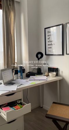 a desk with a laptop computer on top of it next to a chair and window