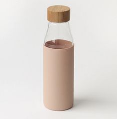 a glass bottle with a wooden lid is shown in front of a plain white background